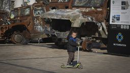 Un niño monta en patineta junto a una exposición de vehículos rusos destruidos en la plaza Mykhailivska del centro de Kiev, Ucrania, el martes 22 de octubre de 2024. (AP Foto/Efrem Lukatsky)