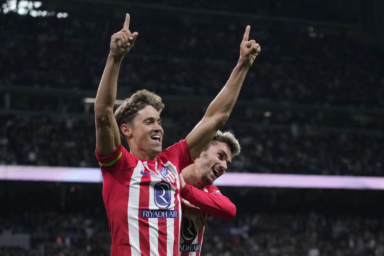 Marcos Llorente del Atlético de Madrid celebra con su compañero Antoine Griezmann tras anotar en el encuentro de la liga española ante el Real Madrid el domingo 4 de febrero del 2024. (AP Foto/Bernat Armangue)