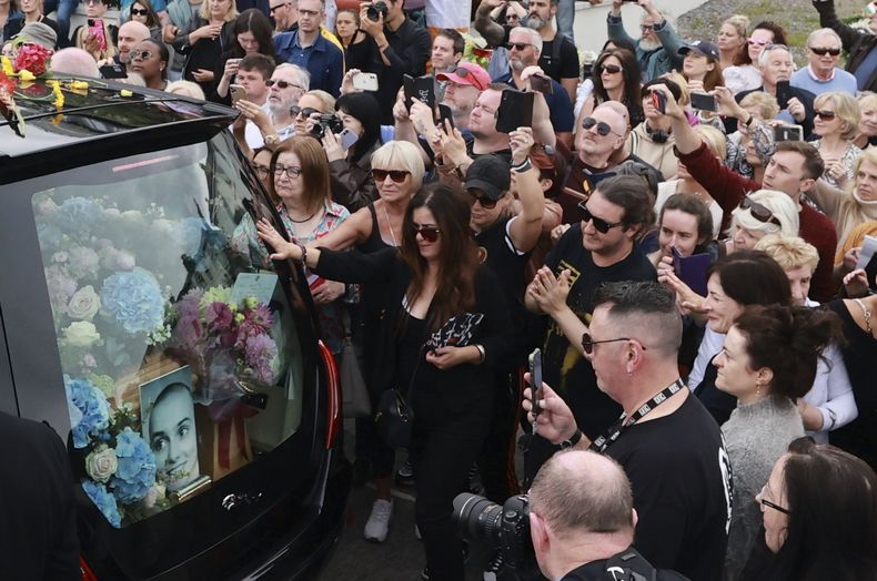 Fans de Sinéad OConnor rodean su carroza fúnebre en su ciudad natal de Bray, en el condado de Wicklow, Irlanda el martes 8 de agosto de 2023. (Liam McBurney/PA vía AP)