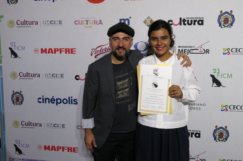 Ernesto Martínez Bucio, izquierda, y Karen Plata de la película El diablo fuma (y guarda las cabezas de los cerillos quemados en la misma caja) posan con el premio al mejor guion en la 23ª edición de la ceremonia de premiación del Festival de Cine de Morelia, en Morelia, México, el viernes 17 de octubre de 2025. (Foto AP/Berenice Bautista)