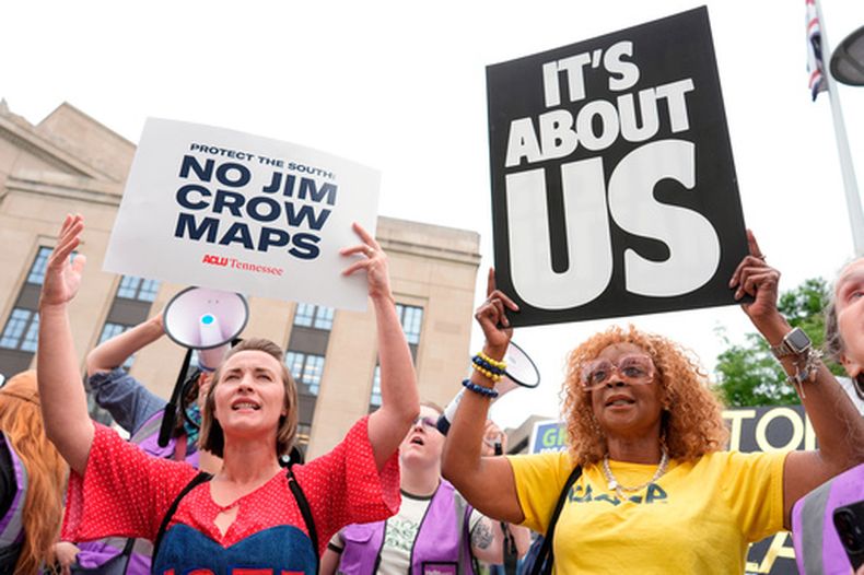 Mandy Cook, izquierda, y Cheryl Woodard, muestran pancartas en una manifestación contra la sesión especial de la Asamblea Legislativa estatal para redistribuir los mapas de votación parlamentaria, el martes 5 de mayo de 2026, en Nashville, Tennessee. (AP Foto/George Walker IV)