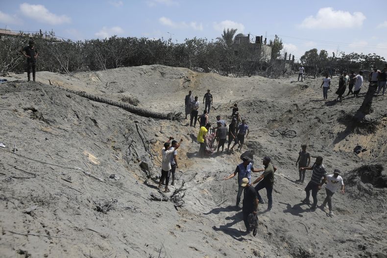 Palestinos buscan cadáveres y sobrevivientes tras un bombardeo israelí en Jan Yunis, en el sur de la Franja de Gaza, el 13 de julio de 2024. (AP Foto/Jehad Alshrafi)