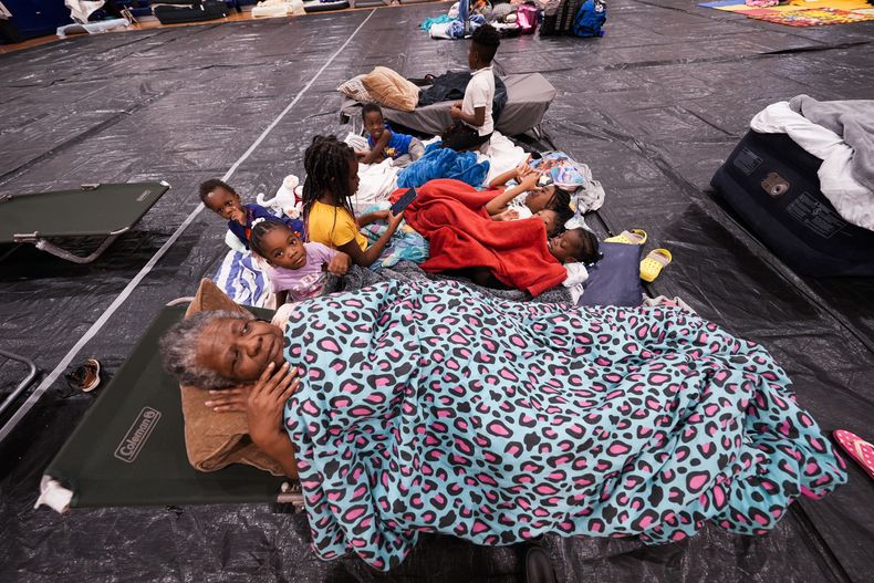 Vera Kelly, de Tallahassee, tumbada en un catre tras ser desalojada a un refugio para huracanes con sus nietos y bisnietos, en la escuela de Fairview, antes de la llegada del huracán Helene, en el condado de Leon, Florida, el 26 de septiembre de 2024. (AP Foto/Gerald Herbert)