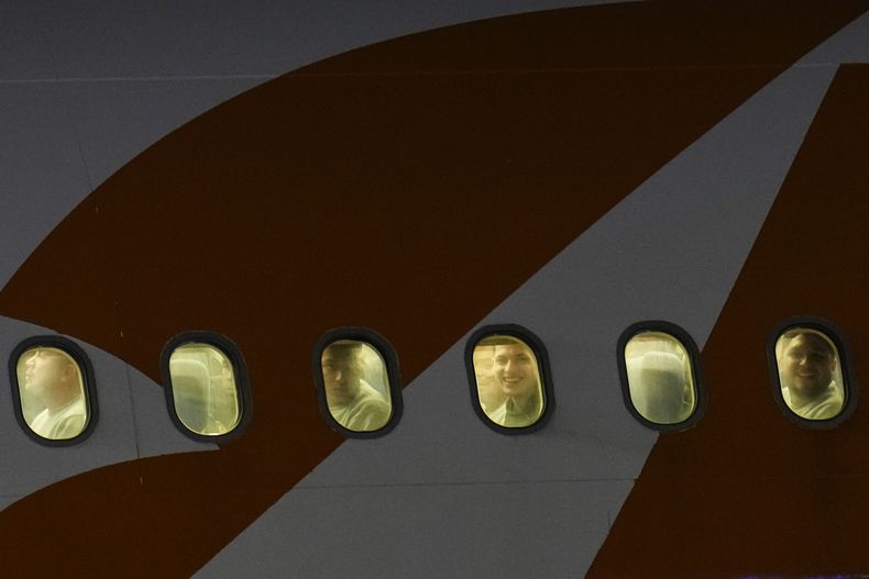 Migrantes venezolanos deportados de Estados Unidos se asoman por las ventanillas de un avión a su llegada al Aeropuerto Internacional Simón Bolívar, en Maiquetía, Venezuela, el lunes 24 de marzo de 2025. (AP Foto/Ariana Cubillos)