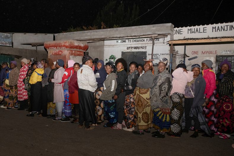 Zambianos hacen fila en el exterior de un centro de votación a las afueras de Lusaka, Zambia, el 13 de agosto de 2026. (AP Foto/Anita Reed)