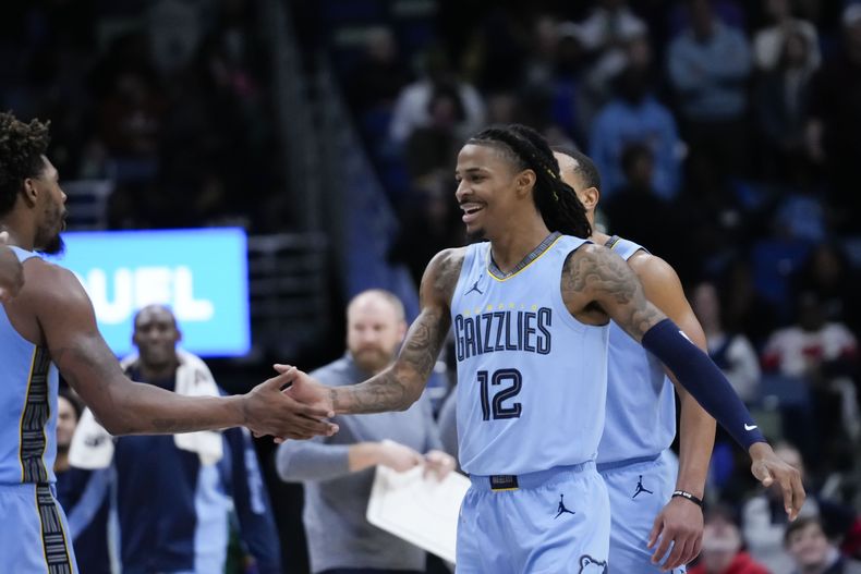 Ja Morant, base de los Grizzlies de Memphis, festeja luego de una clavada en la prórroga del partido del martes 26 de diciembre de 2023, ante los Pelicans de Nueva Orleáns (AP Foto/Gerald Herbert)