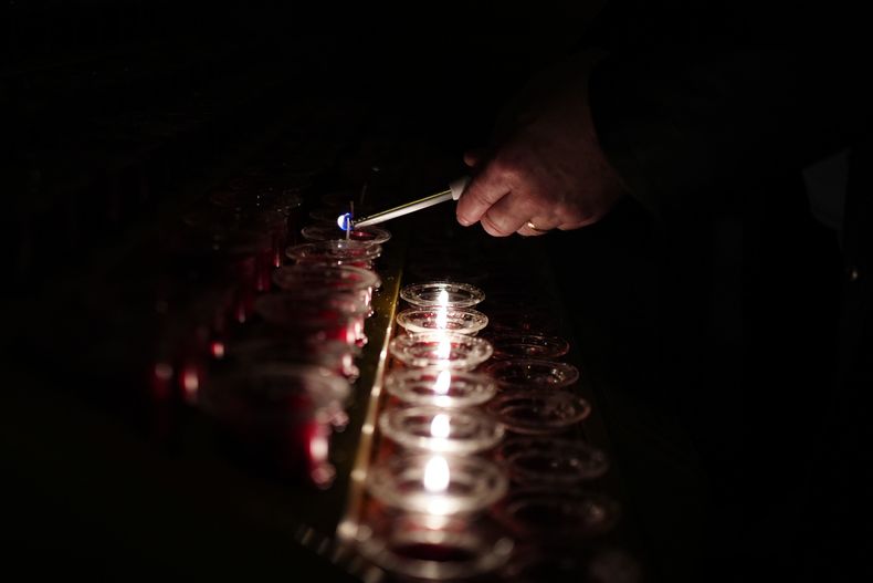 Una persona enciende una vela en la Catedral Metropolitana de Liverpool, Inglaterra, el lunes 21 de abril de 2025, tras el anuncio de la muerte del papa Francisco a los 88 años. (Peter Byrne/PA vía AP)