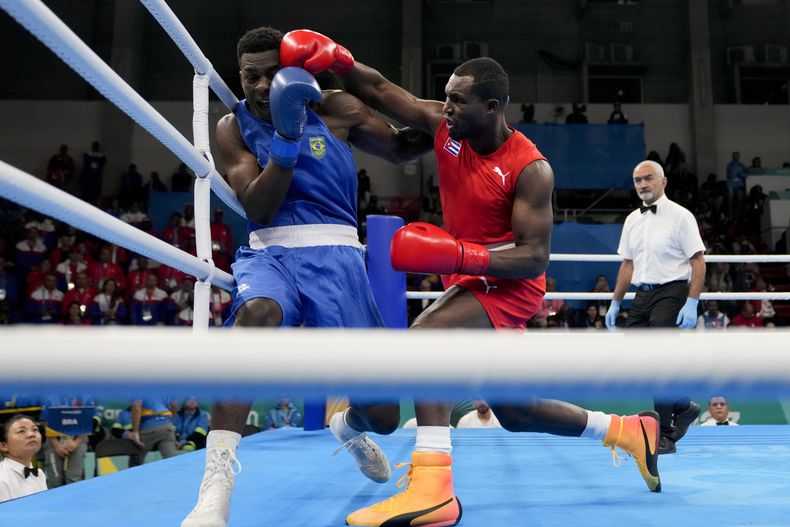 El cubano Julio César La Cruz (derecha) conecta al brasileño Keno Machado en la final de peso pesado en el boxeo de los Juegos Panamericanos en Santiago, Chile, el viernes 27 de octubre de 2023. (AP Foto/Martín Mejía)
