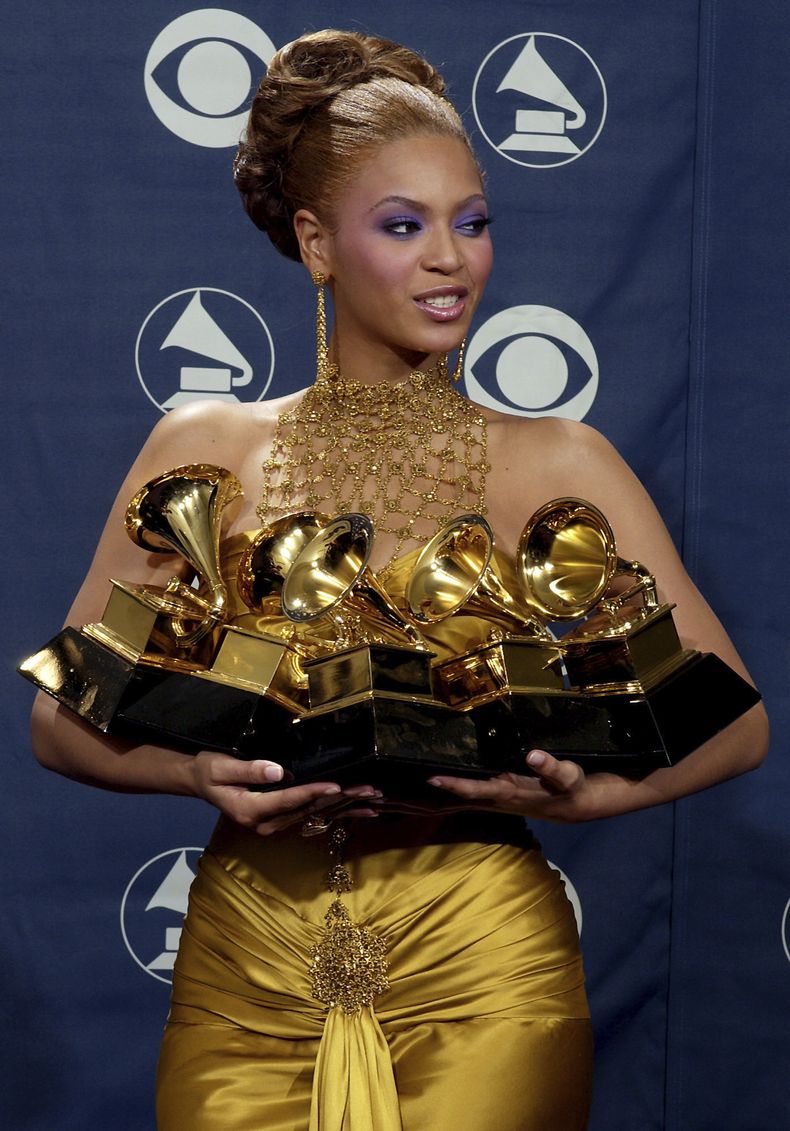 ARCHIVO - Beyonce Knowles sostiene los premios Grammy que ganó durante la 46ª Entrega Anual de los Premios Grammy el 8 de febrero de 2004 en Los Ángeles. (Foto AP/Reed Saxon, archivo)