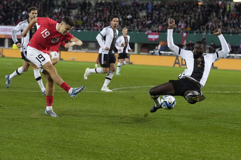 Christoph Baumgartner, de la selección de Austria, realiza un disparo frente a Antonio Rudiger, de Alemania, en el partido del martes 21 de noviembre de 2023 (AP Foto/Matthias Schrader)