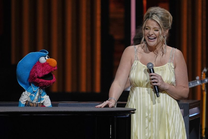 Elmo de Sesame Street, a la izquierda, se presenta con Lauren Alaina en el Grand Ole Opry, el jueves 14 de agosto de 2025, en Nashville, Tennessee. (Foto AP/George Walker IV)