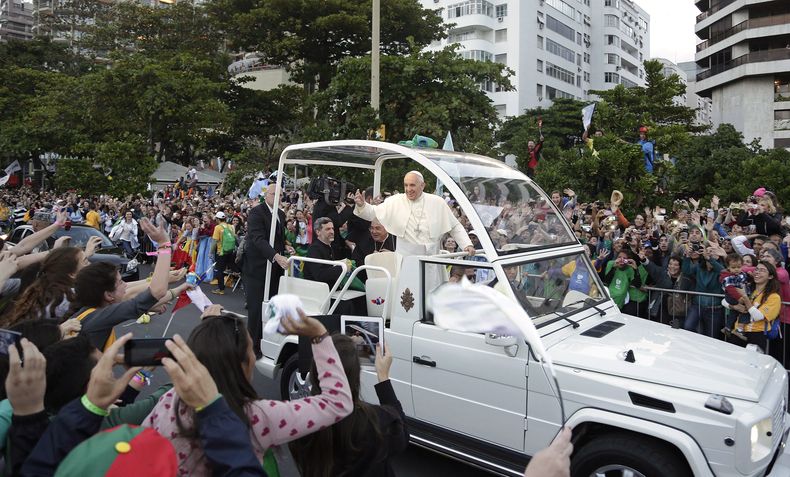 El papa Francisco saluda a la multitud desde su papamóvil frente a la playa de Copacabana, a su llegada para la procesión de las estaciones del vía crucis, el viernes 26 de julio de 2013, en Río de Janeiro. (AP Foto/Andre Penner, archivo)