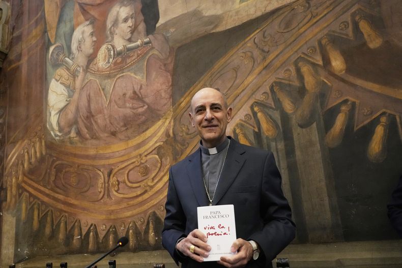 El cardenal Víctor Fernández posa para los fotógrafos con un ejemplar de un libro del papa Francisco titulado Viva la Poesía durante su presentación a los periodistas en Roma, el viernes 21 de marzo de 2025. (AP Foto/Gregorio Borgia)