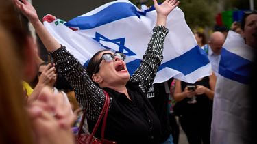 Una mujer extiende los brazos tras el anuncio de que Israel y Hamás han llegado a un acuerdo sobre la primera fase de un plan de paz para detener los combates, el jueves 9 de octubre de 2025, en lo que se conoce como la plaza de los Rehenes en Tel Aviv, Israel. (AP Foto/Emilio Morenatti)