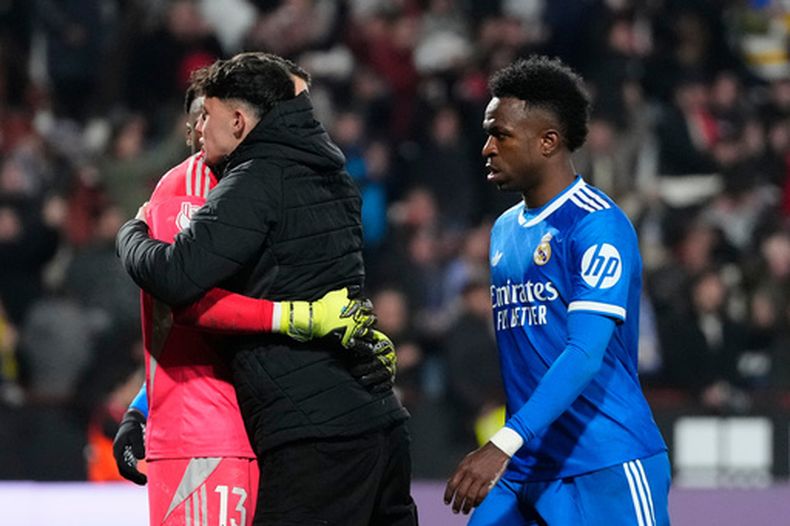 Vinicius Junior, derecha, del Real Madrid, abandona el campo al final del partido correspondiente a los octavos de final de la Copa del Rey mientras los jugadores del Albacete celebran el pase después de eliminar al equipo de la capital española, el miércoles 14 de enero de 2026, en Albacete, España. (AP Foto/Jose Breton)
