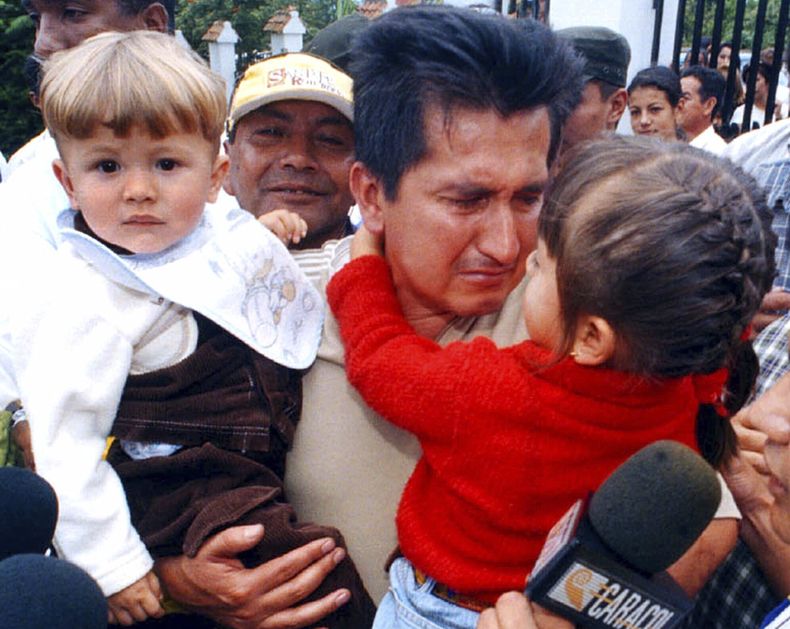 ARCHIVO - El exciclista colombiano Luis Alberto Herrera con sus hijos Luis Alberto, a la izquierda, y Valentina a su llegada a Fusagasuga, Colombia, al sur de Bogotá, Colombia, el 5 de marzo del 2000. (AP Foto, Archivo)