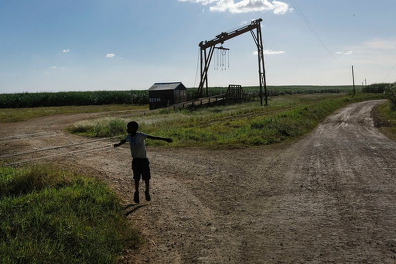 ARCHIVO – Un niño juega cerca de la máquina donde se pesa la caña de azúcar en el vecindario Lima en La Romana, donde Central Romana Corporation, Ltd. realiza sus operaciones de caña de azúcar en República Dominicana, el 17 de noviembre de 2021. (AP Foto/Matias Delacroix, Archivo)