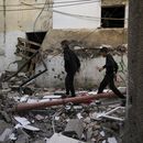 Palestinos caminan junto a un edificio dañado tras una operación del ejército israelí en el campo de refugiados de Yenín, Cisjordania, el domingo 26 de noviembre de 2023. (AP Foto/Majdi Mohammed)