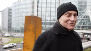 ARCHIVO - El famoso escultor estadounidense Richard Serra posa frente a Slat, una escultura de acero de 1984, después de su reinstalación en La Defense, al oeste de París, el 15 de diciembre de 2008. Serra, conocido por convertir paredes curvas de acero oxidado y otros materiales maleables en obras de arte a gran escala que ahora están repartidas por todo el mundo, murió el martes 26 de marzo de 2024 en su casa en Long Island, Nueva York. Tenía 85 años. (Foto AP/Jacques Brinon, archivo)