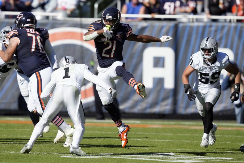 DOnta Foreman (21) runningback de los Bears de Chiago trata de superar al safety Marcus Epps (1) de Las Vega Raiders, en la 2da mitad del juego de la NFL, en Chicago, el domingo 22 de octubre de 2023. (AP Foto/Charles Rex Arbogast)