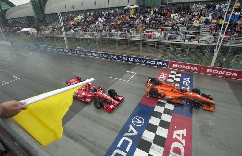 El franc&eacute;s Simon Pagenaud, derecha, y el brasile&ntilde;o Tony Kanaan conducen bajo una bandera de advertencia durante el Gran Premio de Toronto de la IndyCar el s&aacute;bado 19 de julio de 2014. (AP Foto/The Canadian Press, Frank Gunn)