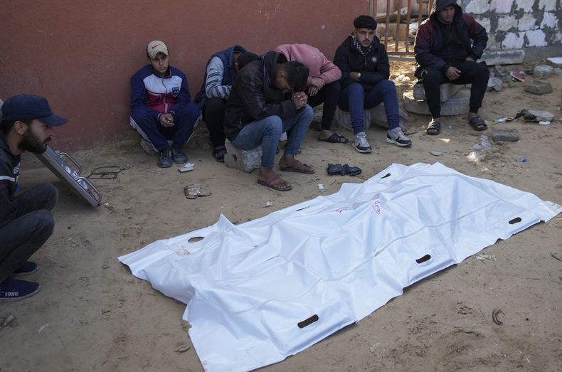 Familiares de un palestino muerto en los ataques nocturnos de Israel lloran junto a su cuerpo, fuera de la morgue del hospital Nasser en el campo de refugiados de Jan Yunis, en el sur de la Franja de Gaza, el sábado 4 de enero de 2025. (AP Foto/Abdel Kareem Hana)