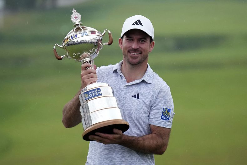 El canadiense Nick Taylor sostiene el trofeo de campeón del Abierto de Canadá tras ganar en el cuarto playoff frente a Tommy Fleetwood el domingo 11 de junio del 2023. (Nathan Denette/The Canadian Press via AP)