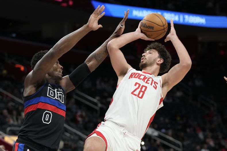 Alperen Sengun, pívot de los Rockets de Houston, dispara frente a Jalen Duren, de los Pistons de Detroit, en el encuentro del viernes 12 de enero de 2024 (AP Foto/Carlos Osorio)