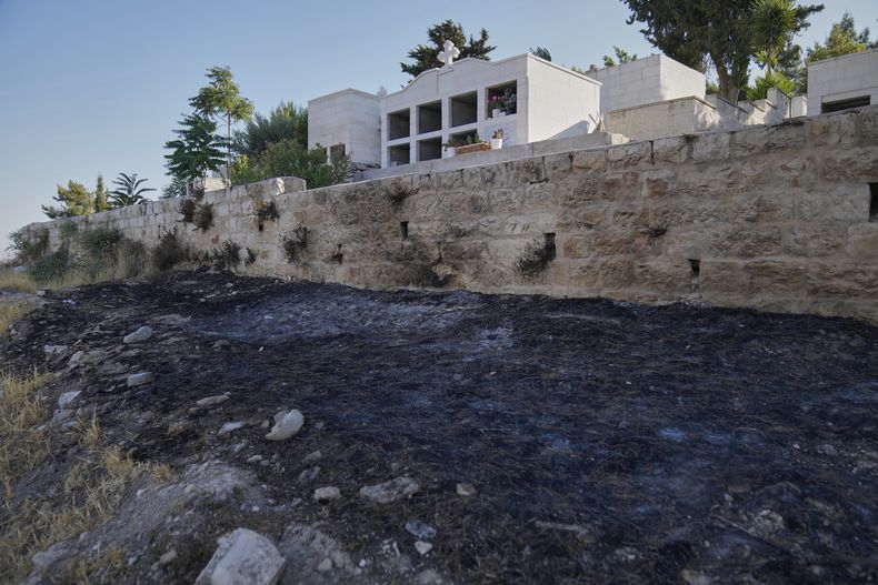 Marcas de carbón que los palestinos dicen que son de un ataque de colonos israelíes en el cementerio cerca de la iglesia ortodoxa griega de San Jorge, en la aldea cisjordana de Taybeh, el lunes 14 de julio de 2025. (AP Foto/Nasser Nasser)