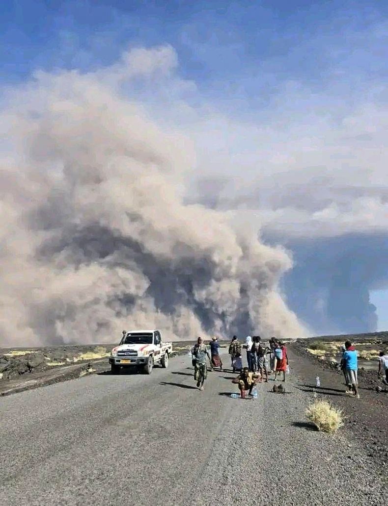 En esta foto publicada por la Oficina de Comunicación del Gobierno de Afar, un grupo de personas observa la columna de cenizas de una erupción del volcán Hayli Gubbi, inactivo desde hace mucho tiempo, en la región de Afar, Etiopía, el domingo 23 de noviembre de 2025. (Oficina de Comunicación del Gobierno de Afar vía AP)