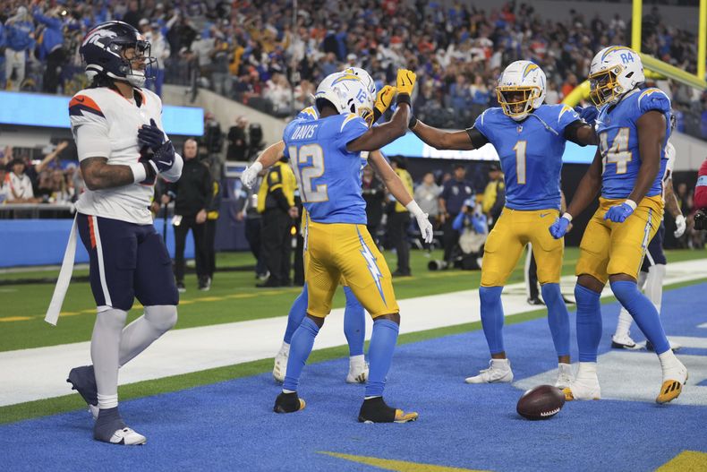 El receptor de los Chargers de Los Ángeles Derius Davis celebra con sus compañeros una recepción de touchdown en el encuentro ante los Broncos de Denver el jueves 19 de diciembre del 2024. (AP Foto/Eric Thayer)