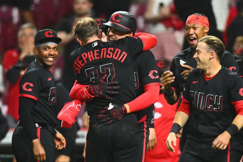 Nathaniel Lowe, centro a la derecha, de los Rojos de Cincinnati, celebra su jonrón de dos carreras con Tyler Stephenson para dejar tendidos en el terreno a los Tigres de Detroit en la novena entrada del juego de béisbol de Grandes Ligas, el viernes 24 de abril de 2026, en Cincinnati. (AP Photo/Ben Jackson)