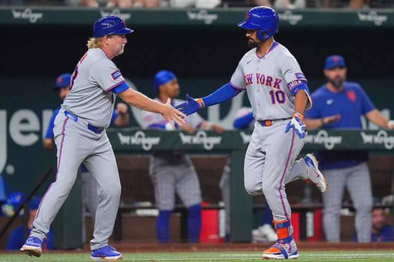Marcus Semien es felicitado por el entrenador de tercera base de los Mets de Nueva York Jacob Latz al correr las bases tras batear un jonrón solitario en la octava entrada ante los Rangers de Texas el miércoles 23 de septiembre del 2026. (AP Foto/LM Otero)