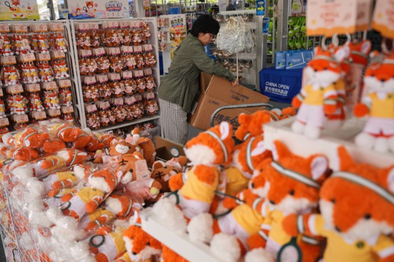 Una trabajadora prepara muñecos de felpa para vender en una tienda de recuerdos durante el torneo de tenis Abierto de China, en Beijing, el miércoles 30 de septiembre de 2026. (AP Foto/Andy Wong)