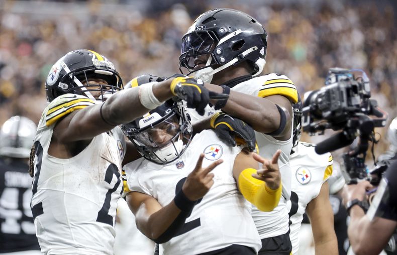 El QB de los Steelers de Pittsburgh, Justin Fields, centro, posa con el corredor Najee Harris, izquierda, y el tight end Darnell Washington, derecha, después de anotar un touchdown contra los Raiders de Las Vegas el domingo 13 de octubre de 2024, en Las Vegas. (Steve Marcus/Las Vegas Sun vía AP)