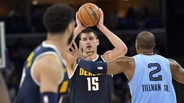 El pívot de los Nuggets de Denver Nikola Jokic (15) mira a quien pasar el balón mientras es defendido por el alero de los Grizzlies de Memphis Xavier Tillman Sr. (2) durante la 2da mitad del juego de NBA, en Memphis, Tennessee, el viernes 27 de octubre de 2023. (AP Foto/Brandon Dill)