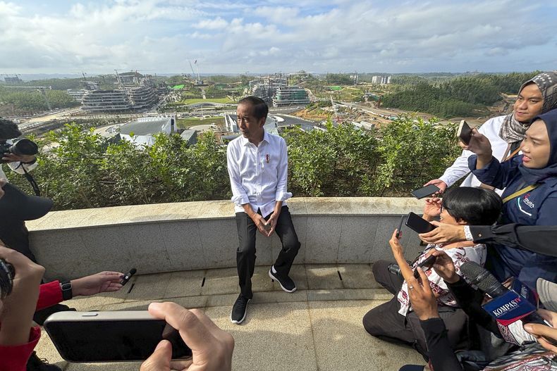 El presidente de Indonesia, Joko Widodo, en el centro, habla con los medios en la nueva capital Nusantara en Penajam Paser Utara, Kalimantan Oriental, Indonesia, el lunes 29 de julio de 2024. Widodo empezó a trabajar el lunes desde el nuevo palacio presidencial en la nueva capital del país, Nusantara, donde espera pasar los últimos meses de su presidencia. (AP foto/ Fadlan Syam)