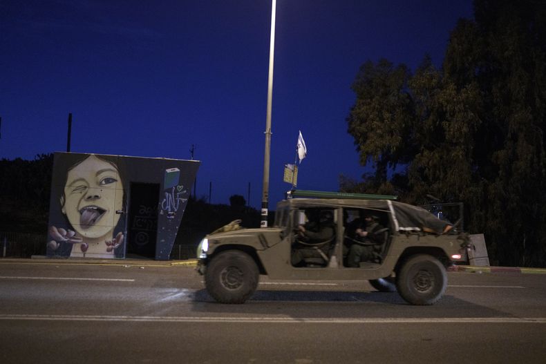 Soldados israelíes pasan junto a un refugio antibombas cerca de la frontera de Israel con la Franja de Gaza, el sábado 6 de enero de 2024. (AP Foto/Leo Correa)