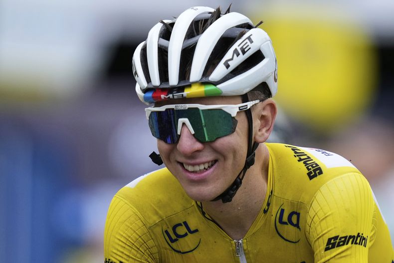 Un sonriente Tadej Pogacar de Eslovenia, vistiendo el maillot amarillo de líder general, cruza la línea de meta de la vigésima etapa de la carrera ciclista del Tour de Francia, de 184.2 kilómetros (114.5 millas), con salida en Nantua y llegada en Pontarlier, Francia, el sábado 26 de julio de 2025. (AP Photo/Mosaab Elshamy)