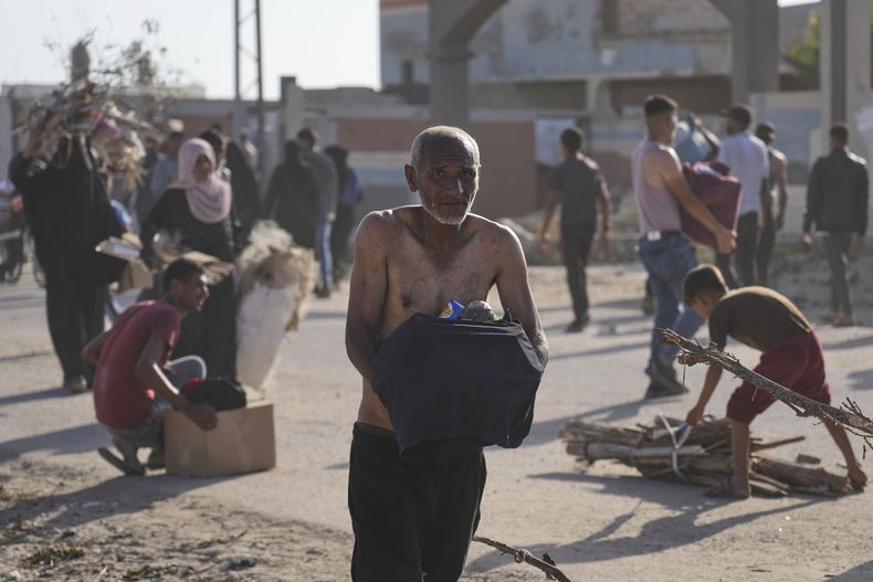 Palestinos cargan con cajas con comida y ayuda humanitaria repartidas por Gaza Humanitarian Foundation, una organización respaldada por EEUU y aprobada por Israel, en Rafah, en el extremo sur de la Franja de Gaza, el 27 de mayo de 2025. (AP Foto/Abdel Kareem Hana)