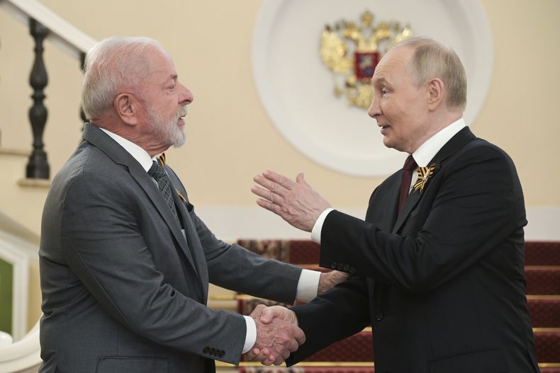 El presidente de Rusia, Vladímir Putin, saluda al presidente de Brasil, Luiz Inácio Lula da Silva, antes del desfile militar del Día de la Victoria, en Moscú, Rusia, el viernes 9 de mayo de 2025, en el 80vo aniversario de la Unión Soviética sobre la Alemania nazi en la II Guerra Mundial. (Alexey Nikolsky/Sputnik, Kremlin Pool Foto via AP)