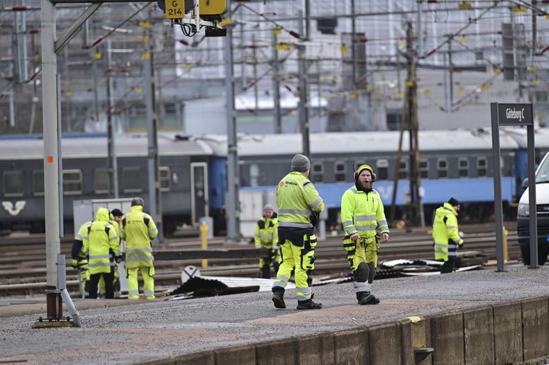 Trabajadores retiran parte de un techo arrancado por fuertes vientos en la principal estación de trenes de Goteborg, Suecia, el viernes 23 de febrero de 2024. (Björn Larsson Rosvall/TT News Agency vía AP)