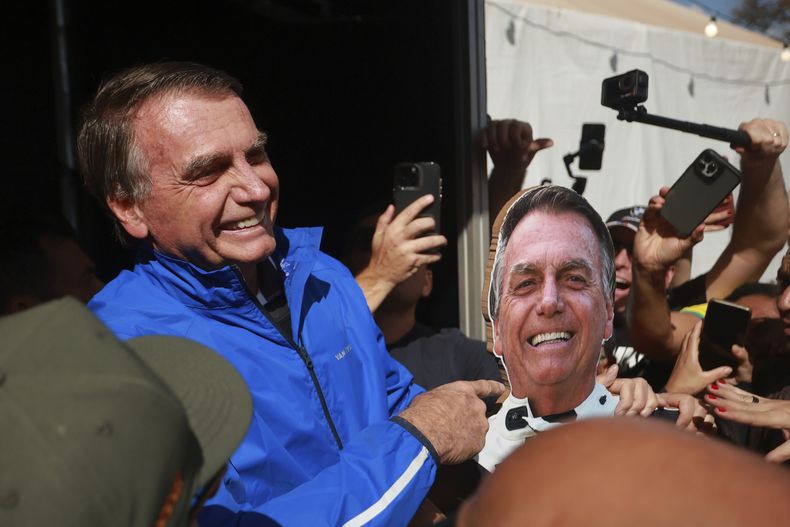 El expresidente brasileño Jair Bolsonaro señala a una foto de él el 29 de julio de 2025, en Brasilia. (AP foto/Luis Nova)
