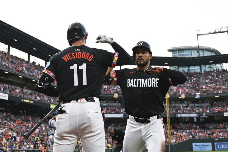 El venezolano Anthony Santander festeja con Jordan Westburg, su compañero en los Orioles de Baltimore, luego de batear un jonrón en el juego del sábado 29 de junio de 2024, ante los Rangers de Texas (AP Foto/Terrance Williams)