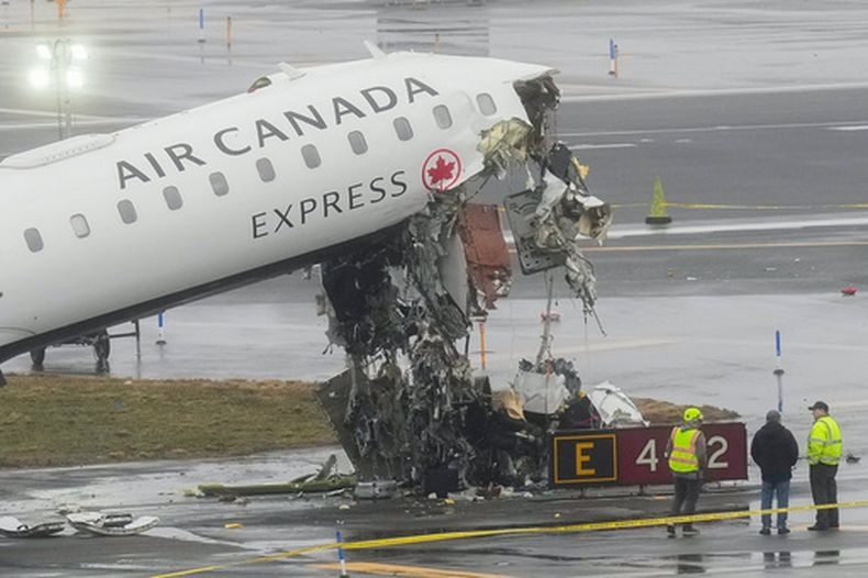 ARCHIVO - Funcionarios investigan el lugar, el lunes 23 de marzo de 2026, donde un avión de Air Canada quedó detenido tras colisionar con un camión de bomberos de la Autoridad Portuaria en el aeropuerto LaGuardia, poco después de aterrizar la noche del domingo en Nueva York. (Foto AP/Seth Wenig, archivo)
