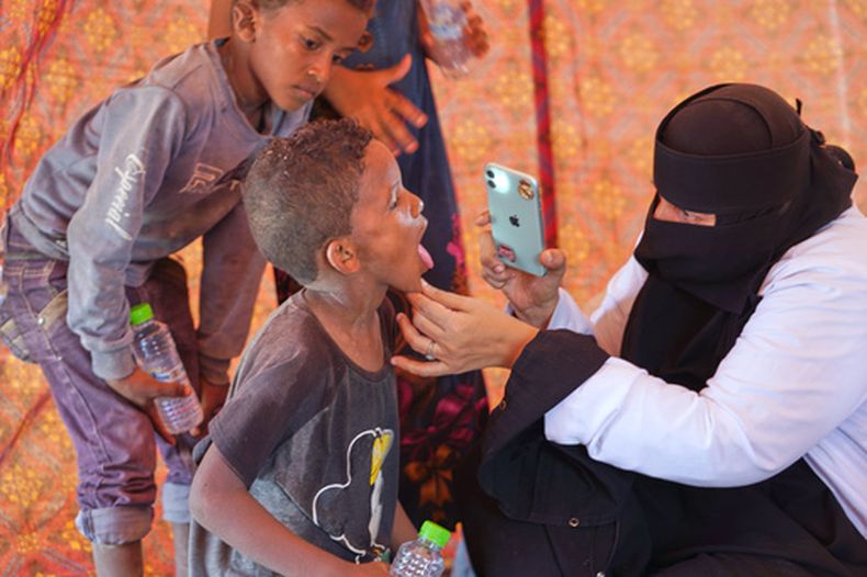 Una médica examina a un niño desplazado en el campamento de Al-Firdaws en Ras Imran, a las afueras de Adén, Yemen, el lunes 14 de septiembre de 2026. (AP Foto/Abdulnasser Alseddik)