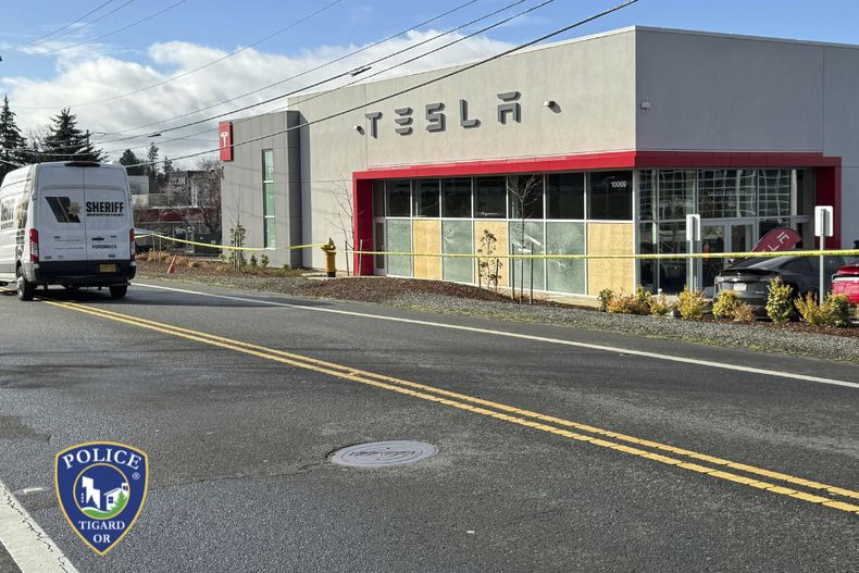 En esta imagen difundida por el Departamento de Policía de Tigard se ve una ventana tapiada en una agencia de Tesla, el jueves 13 de marzo de 2025, en Tigard, Oregon, después de que se efectuaron disparos contra el lugar por segunda ocasión en una semana. (Departamento de Policía de Tigard vía AP)