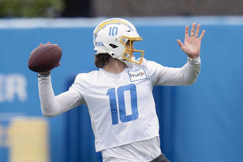 ARCHIVO - Justin Herbert quarterback de los Chargers de Los Ángeles realiza una rutina de entrenamiento en el campamento del equipo de la NFL en Costa Mesa, California. Lunes 22 de mayo de 2023. (AP Foto/Jae C. Hong, Archivo)