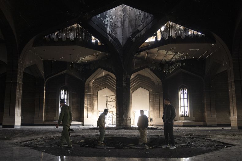 Combatientes sirios pisotean la tumba quemada del fallecido presidente sirio Hafez Assad el martes 17 de diciembre de 2024, en su mausoleo en Qardaha, Siria. (AP Foto/Leo Correa)
