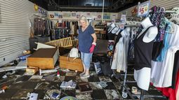 Jill Rice observa los daños causados en su tienda por la inundación provocada por el paso del huracán Helene, el 27 de septiembre de 2024, en Gulfport, Florida. (AP Foto/Mike Carlson)